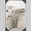 Two men outside row of barracks (ddr-ajah-2-391)