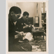 Two men demonstrating carving at Japanese Pavilion (ddr-densho-426-2097)