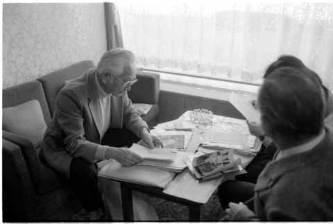 Loni Ding, Barry Saiki and Harry Fukuhara looking through clippings (ddr-densho-1007-1166)