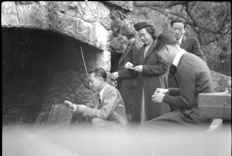 Two women and three men standing by large outside fireplace (ddr-densho-426-1965)