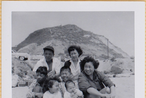 Two women, a man and four children on beach (ddr-densho-522-358)