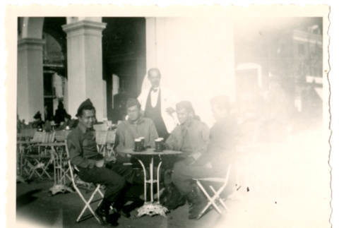 Soldiers sitting around outdoor table with waiter (ddr-densho-368-278)