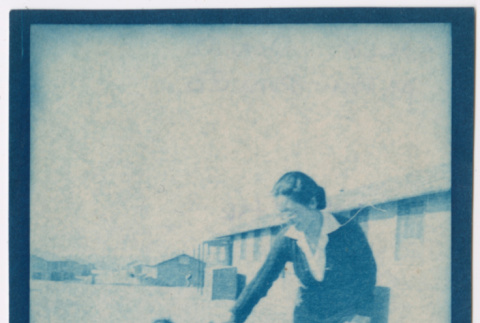 Woman and toddler walking near barracks (ddr-densho-329-1281)