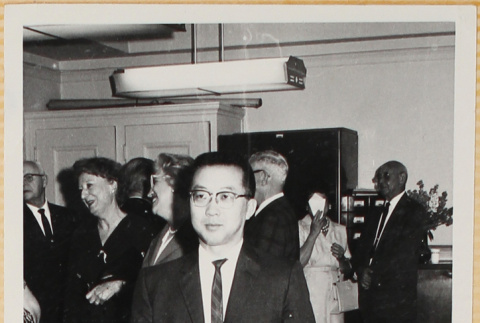 Man in suit, with group in background (ddr-densho-522-85)
