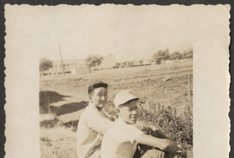 Two men sitting in a field (ddr-densho-433-1109)
