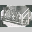 Three men sitting on steps of barracks.  Joe Iwataki in center (ddr-ajah-2-395)