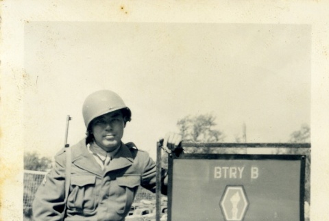 Soldier next to the 522nd Field Artillery Battalion sign (ddr-densho-22-335)