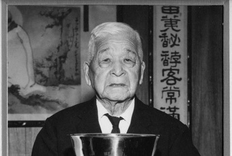 Fujitaro Kubota holding a gift received at a ceremony (ddr-densho-354-76)