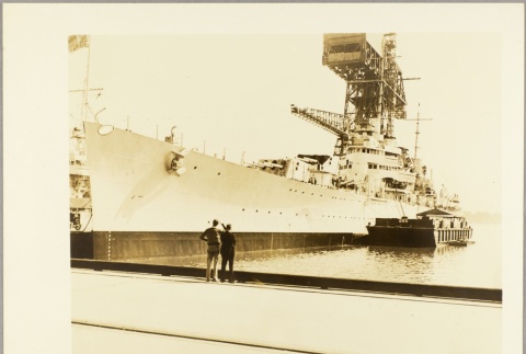 Two men standing on a dock next to the USS Philadelphia (ddr-njpa-13-125)