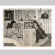 Two girls sitting on beds in the barracks at Manzanar (ddr-csujad-52-10)