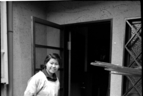 Woman in smock standing in doorway (ddr-densho-426-2298)