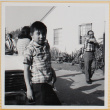 Boy standing by car in driveway (ddr-densho-522-91)