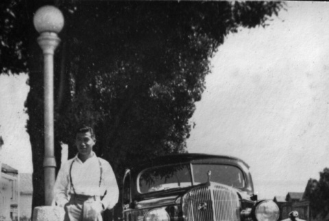 Tsutomu Inouye standing by car (ddr-ajah-6-476)