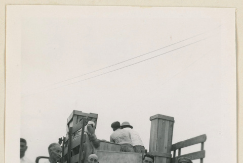 Men stand with a truck bound for Tule Lake (ddr-densho-37-876)