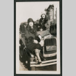 two women sitting on the hood of a car (ddr-densho-378-764)