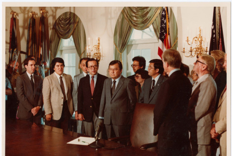 Group of men at desk in White House, Signing of Commission of Wartime Relocation and Internment of Citizens Act into law (ddr-densho-393-3)