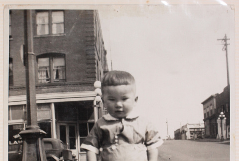 Photo of a baby standing on a city street (ddr-densho-483-412)