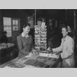 Young Nisei girl purchasing Christmas wrappings in cooperative notion store at Granada incarceration camp (ddr-csujad-14-40)