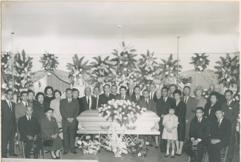 Group of people standing and seated around coffin (ddr-densho-332-47)