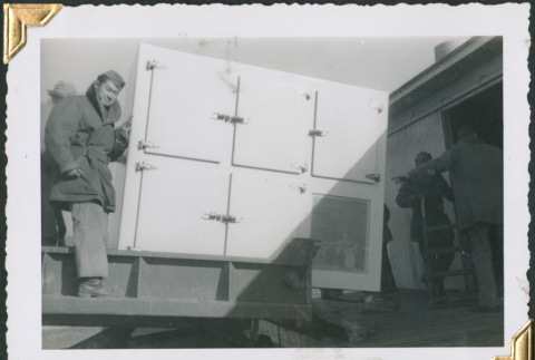 Man with large icebox on loading dock (ddr-densho-434-258)