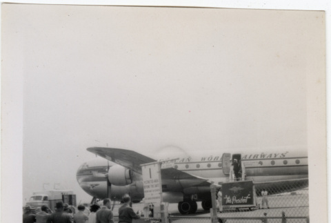 Group standing by fence at airport (ddr-densho-426-864)