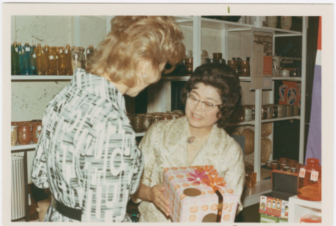 Tomoye Takahashi with unknown woman by product display (ddr-densho-426-1093)