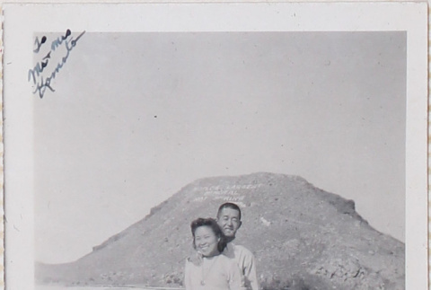 Couple standing on boardwalk with hill in background (ddr-densho-464-102)