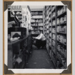 Man squatting behind a counter (ddr-densho-542-102)