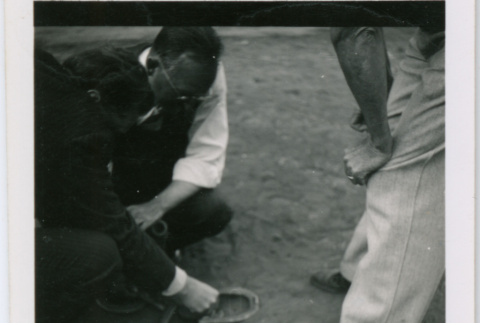Men leaning over objects (ddr-densho-377-1647)