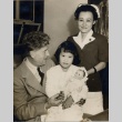 Nurse and man with young girl holding a doll in his lap (ddr-njpa-2-1129)