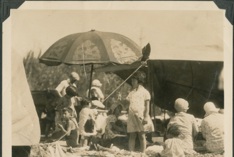 Group of children and adults at a picnic on a beach (ddr-densho-483-509)