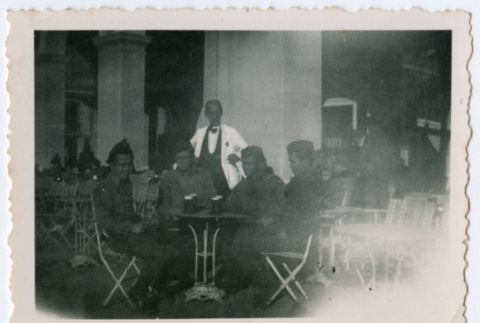 Soldiers sitting around outdoor table with waiter (ddr-densho-368-213)