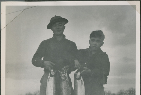 Masao Sakagami and a teenager holding fish (ddr-densho-201-846)