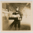 Man outside train, carrying box (ddr-densho-426-1386)