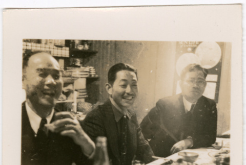 Three men seated at table with plates of food (ddr-densho-426-1700)
