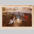 Three people on a picnic next to parking lot (ddr-densho-377-2187)