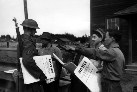 Soldier and Nisei posting Civilian Exclusion Order No. 1 (ddr-densho-36-27)