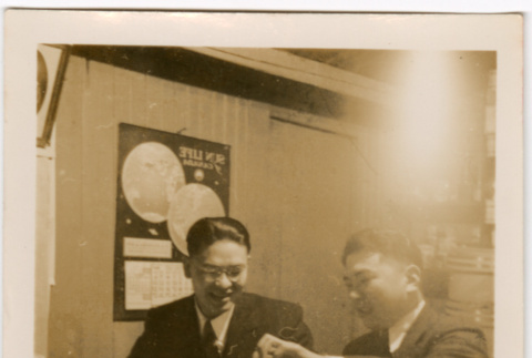 Two men sitting at a table with food (ddr-densho-426-2114)