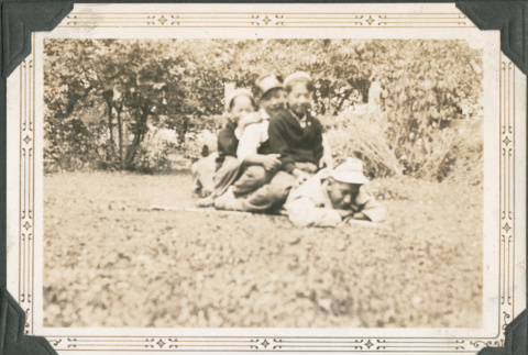Three boys sitting on another boy (ddr-densho-316-295)