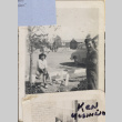 Woman sitting on fence with barracks in background (ddr-densho-466-238)