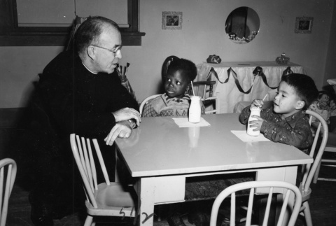 (Photograph) - Image of priest and children at table (ddr-densho-330-261-master-390029d4bc)