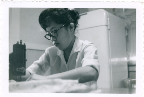 Woman using sewing machine (ddr-densho-430-196)