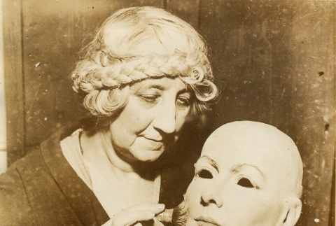 A woman painting a mask (ddr-njpa-1-2023)