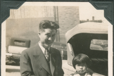 Man and girl standing on running board of car (ddr-densho-316-362)