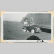 A girl riding in a toy car (ddr-densho-300-143)