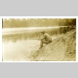Soldier fishing on the banks of a river (ddr-densho-22-203)