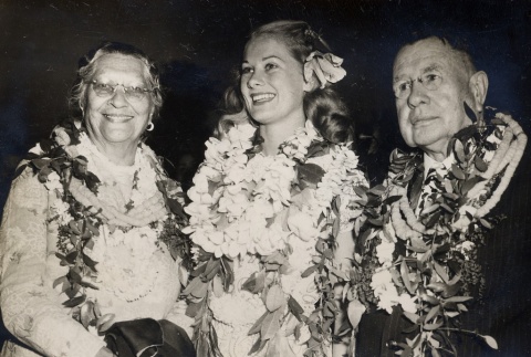 John H. Wilson, his wife and a young woman posing with leis (ddr-njpa-2-900)