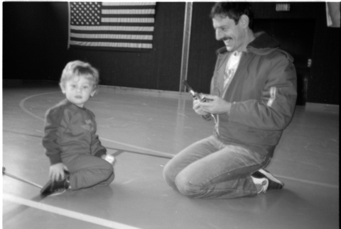 Man with child on gym floor (ddr-densho-1007-1258)