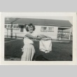 Woman holding up laundry (ddr-manz-7-42)