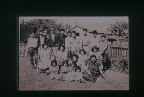 (Slide) - Image of group of people seated and standing on grass (ddr-densho-330-212-master-ca213316b2)